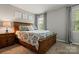 Cozy bedroom with a wooden bed frame, patterned bedding, and neutral wall decor, creating a calming atmosphere at 9238 Deer Spring Ln, Charlotte, NC 28210