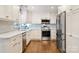 A close up of the bright kitchen with stainless appliances and hardwood floors at 9238 Deer Spring Ln, Charlotte, NC 28210