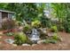 Beautiful backyard water feature with landscaping, lush greenery and rocks at 9238 Deer Spring Ln, Charlotte, NC 28210
