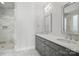 Bathroom with double sink vanity, decorative mirrors, and tiled walk in shower at 945 Westbrook Dr # A, Charlotte, NC 28202