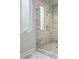 Beautiful bathroom shower with glass door, marble-look tile, and custom floor tiling at 945 Westbrook Dr # A, Charlotte, NC 28202