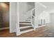 Modern staircase featuring wood treads, white risers, and an elegant decorative wall design at 945 Westbrook Dr # A, Charlotte, NC 28202