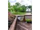 Cozy deck space with wooden railing overlooking a manicured lawn and mature trees at 9532 Cadman Ct, Cornelius, NC 28031