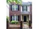 Charming brick townhome with black shutters and an inviting entrance featuring a small decorative fence at 9532 Cadman Ct, Cornelius, NC 28031