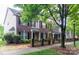 Row of brick townhomes featuring black shutters and wrought iron fence along a tree lined sidewalk at 9532 Cadman Ct, Cornelius, NC 28031