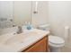 Cozy half bathroom featuring a toilet, sink, and a wooden vanity at 10016 Lawing School Rd, Charlotte, NC 28214