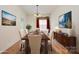 Staged dining room features warm wood floors and a tasteful sideboard for elegant meals at 10016 Lawing School Rd, Charlotte, NC 28214