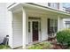 Welcoming front door featuring decorative wreath and sidelights, complemented by charming porch seating at 10016 Lawing School Rd, Charlotte, NC 28214