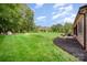 Expansive backyard featuring lush green grass, mature trees, well-maintained landscaping, and a patio area perfect for outdoor living at 1010 Nutall Oak Ln, Belmont, NC 28012