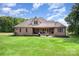 Beautiful brick home with a well-manicured lawn, inviting back porch, and mature trees, perfect for outdoor living and entertaining at 1010 Nutall Oak Ln, Belmont, NC 28012