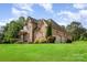 Stunning stone and brick home showcasing professional landscaping, an attached two-car garage, and classic architectural details at 1010 Nutall Oak Ln, Belmont, NC 28012