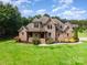 Beautiful two-story home features a stone facade, brick accents, and lush lawn at 1010 Nutall Oak Ln, Belmont, NC 28012