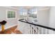 Elegant staircase with black banister, hardwood floors, and natural light from large windows at 1010 Nutall Oak Ln, Belmont, NC 28012