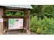 Seven Oaks Preserve Trail entrance featuring a map and information kiosk amidst lush greenery and wildflowers at 1010 Nutall Oak Ln, Belmont, NC 28012