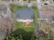 Aerial view of a house with a well-maintained backyard, a deck, lush green grass, and mature trees at 104 Steamboat Dr, Mount Holly, NC 28120