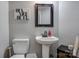 Charming powder room featuring a pedestal sink and framed mirror, perfect for guests at 104 Steamboat Dr, Mount Holly, NC 28120