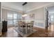 Elegant dining room with modern lighting fixture, wainscoting and hardwood floors at 104 Steamboat Dr, Mount Holly, NC 28120
