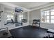 Home gym with large mirrors, rubber flooring, a mounted television, and various workout equipment at 104 Steamboat Dr, Mount Holly, NC 28120