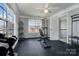 Home gym featuring multiple windows, ceiling fan, and a variety of workout equipment on a rubber floor at 104 Steamboat Dr, Mount Holly, NC 28120