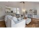 Bright living room showcasing hardwood floors, large sofa, and a view into the kitchen at 104 Steamboat Dr, Mount Holly, NC 28120