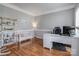 Bright home office with hardwood floors, white desk, decorative shelving, and natural light at 104 Steamboat Dr, Mount Holly, NC 28120