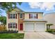 Charming two-story home with red door, brick facade and a well-manicured front lawn at 10431 Plantain Ct, Charlotte, NC 28213