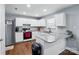 Well-lit kitchen with white cabinets, stainless steel appliances, granite countertops and hardwood floors at 10431 Plantain Ct, Charlotte, NC 28213