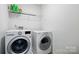 Laundry room with a front load washer and dryer and wire rack shelving at 10431 Plantain Ct, Charlotte, NC 28213