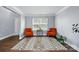Bright living room featuring hardwood floors, a colorful area rug, two orange chairs and natural light at 10431 Plantain Ct, Charlotte, NC 28213