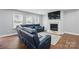 Cozy living room showcasing hardwood floors, a fireplace and blue leather reclining sectional at 10431 Plantain Ct, Charlotte, NC 28213