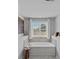 Bright bathroom featuring a soaking tub under a window with neutral tile surround at 10906 Charmont Pl, Huntersville, NC 28078