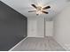 Spacious bedroom with a ceiling fan, plush carpet, and large closet at 10906 Charmont Pl, Huntersville, NC 28078
