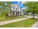Beautiful two-story home featuring a lush green lawn, inviting front porch, and a welcoming facade at 10906 Charmont Pl, Huntersville, NC 28078
