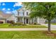 Charming two-story home with a well-manicured lawn, inviting front porch, and attached two-car garage at 10906 Charmont Pl, Huntersville, NC 28078