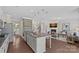 Open concept kitchen with granite counters, island seating, and sightlines to the living room with fireplace at 10906 Charmont Pl, Huntersville, NC 28078