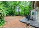 A spacious backyard with a wooden deck and a seating area surrounded by lush greenery and tall trees at 11102 Sundown Ln, Charlotte, NC 28226