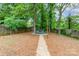 Large backyard featuring a fire pit area with chairs and a gravel walkway at 11102 Sundown Ln, Charlotte, NC 28226