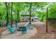 Spacious backyard with a fire pit area, mature trees, and a view of the house at 11102 Sundown Ln, Charlotte, NC 28226