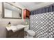 Cozy bathroom with a modern vanity, neutral tile, decorative mirror, and a patterned shower curtain at 11102 Sundown Ln, Charlotte, NC 28226