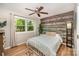This cozy bedroom features a wood accent wall, a window to the outdoors, and wood flooring at 11102 Sundown Ln, Charlotte, NC 28226