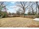 Large, fenced backyard featuring straw-covered ground, a shed, and mature trees at 112 Bickett Ave, Gastonia, NC 28052