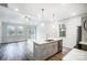 Modern kitchen with stainless steel appliances, island with sink, and open layout to the living room at 112 Bickett Ave, Gastonia, NC 28052
