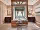 Beautiful primary bathroom featuring double vanities, jacuzzi tub with decorative wood frame, and tile flooring at 1140 Fern Hill Rd, Mooresville, NC 28117