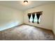 Cozy bedroom features carpeted floors and a large window providing natural light at 1140 Fern Hill Rd, Mooresville, NC 28117