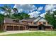 Stunning two-story home featuring a three-car garage, inviting front porch, and lush green lawn at 1140 Fern Hill Rd, Mooresville, NC 28117