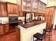 Modern kitchen with granite countertops, stainless steel appliances, wooden cabinetry, and a breakfast bar at 1140 Fern Hill Rd, Mooresville, NC 28117