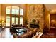 Bright living room with a striking stone fireplace, hardwood floors and soaring windows to the back yard at 1140 Fern Hill Rd, Mooresville, NC 28117