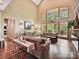 Bright living room boasts soaring ceilings, large windows, hardwood floors and comfortable seating at 1140 Fern Hill Rd, Mooresville, NC 28117