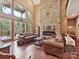Bright living room featuring stone fireplace, hardwood floors and large windows with scenic views at 1140 Fern Hill Rd, Mooresville, NC 28117