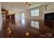 Open-concept living room featuring hardwood floors, a fireplace, and seamless flow to the kitchen at 11505 Sweetbriar Ridge Dr, Charlotte, NC 28269